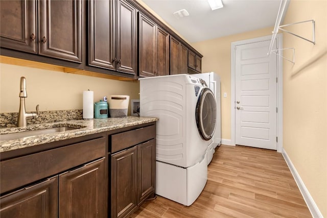 2560 Square Nail Cv, Leander, TX 78641 - laundry area with cabinet space, light wood-style floors, baseboards, and washer and clothes dryer