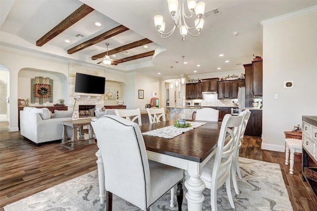 2560 Square Nail Cv, Leander, TX 78641 - dining area featuring ceiling fan, dark wood finished floors, recessed lighting, a stone fireplace, and arched walkways