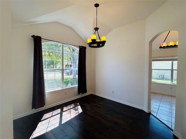 unfurnished room with arched walkways, lofted ceiling, a healthy amount of sunlight, and a chandelier