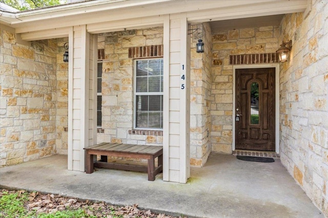 entrance to property with stone siding and covered porch