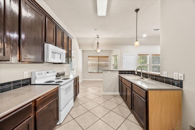 kitchen featuring dark brown cabinetry, visible vents, a sink, and white appliances