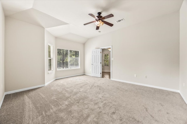 interior space with vaulted ceiling, a ceiling fan, carpet floors, baseboards, and visible vents