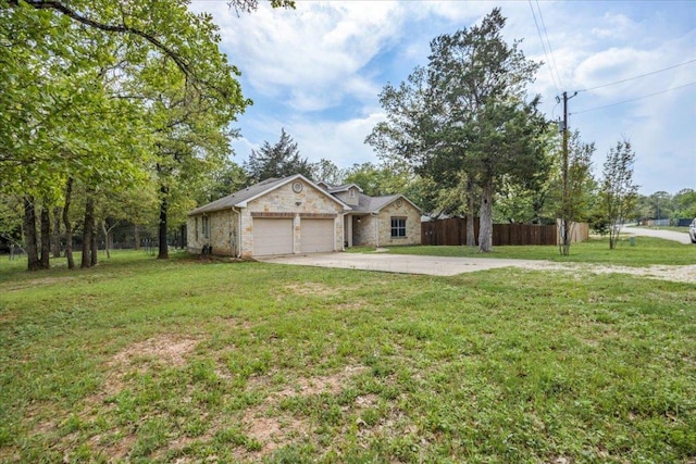 ranch-style home featuring an attached garage, fence, and a front yard