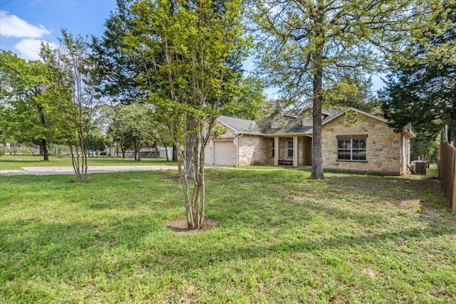 single story home with stone siding, an attached garage, a front lawn, and fence