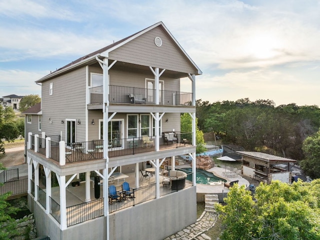 19206 Hornsby Ln, Spicewood, TX 78669 - back of property with a balcony, a patio area, and an outdoor pool
