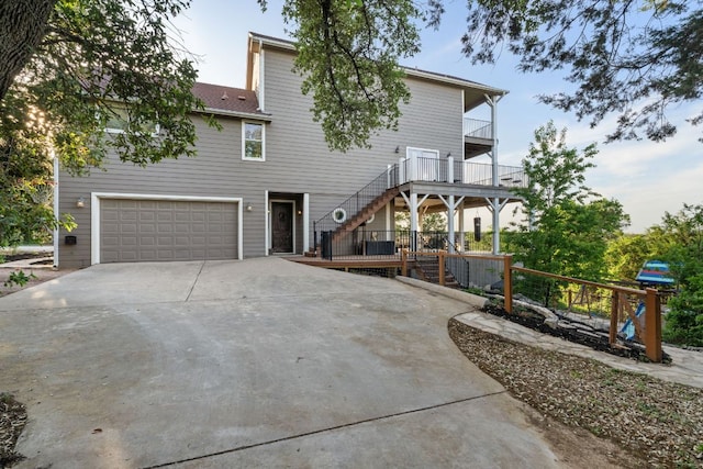 19206 Hornsby Ln, Spicewood, TX 78669 - view of front of home featuring stairway, an attached garage, concrete driveway, and a balcony
