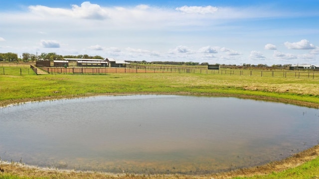 view of water feature with fence, a rural view, an enclosed area, and an exterior structure