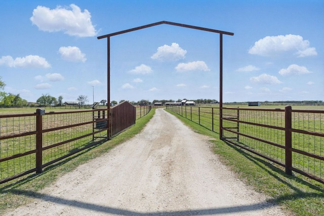 view of road with driveway, a rural view, and a gated entry