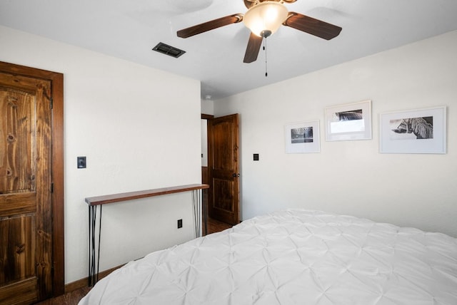 bedroom with wood finished floors, visible vents, and ceiling fan