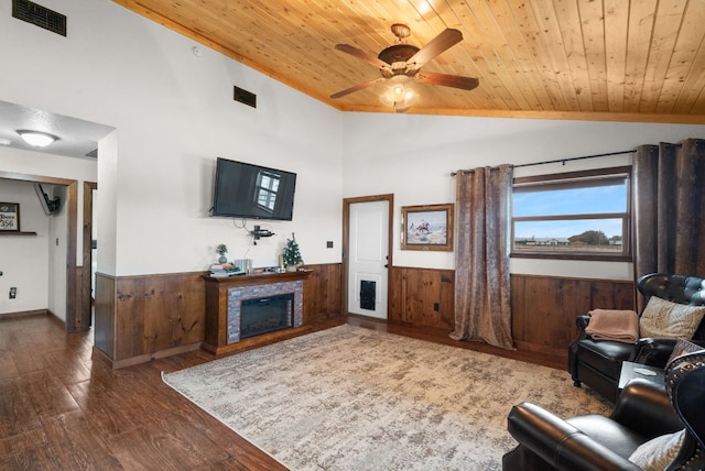 living room featuring wainscoting, vaulted ceiling, visible vents, wood finished floors, and wooden ceiling