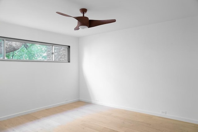 unfurnished room with light wood-style floors, a ceiling fan, and baseboards