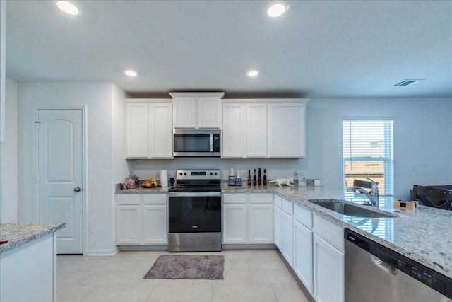 17216 Farmhouse Ln, Elgin, TX 78621 - kitchen with appliances with stainless steel finishes, a sink, light stone countertops, white cabinets, and recessed lighting