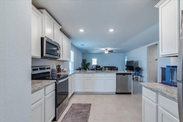 17216 Farmhouse Ln, Elgin, TX 78621 - kitchen with stainless steel appliances, open floor plan, ceiling fan, a peninsula, and white cabinetry