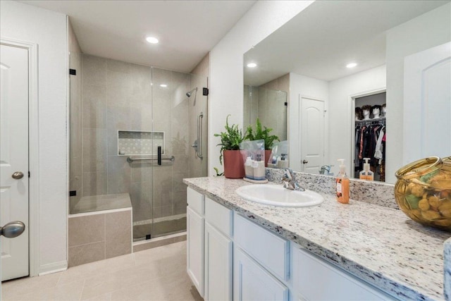 17216 Farmhouse Ln, Elgin, TX 78621 - bathroom featuring tile patterned flooring, vanity, a stall shower, recessed lighting, and a spacious closet