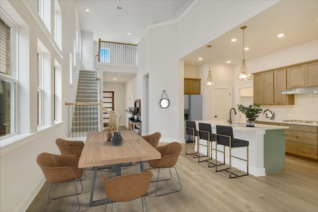 1404 S Brook Dr, Leander, TX 78641 - dining room with baseboards, light wood-style floors, a high ceiling, stairs, and recessed lighting