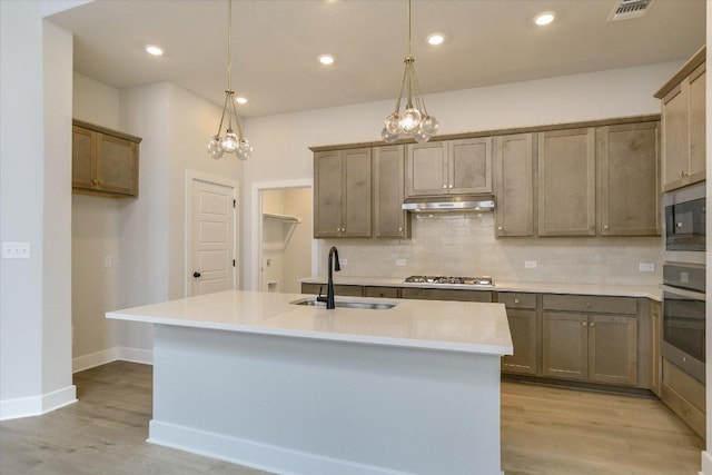 1404 S Brook Dr, Leander, TX 78641 - kitchen with stainless steel appliances, a sink, decorative backsplash, under cabinet range hood, and recessed lighting