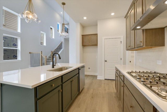 1404 S Brook Dr, Leander, TX 78641 - kitchen featuring wall chimney exhaust hood, a sink, a chandelier, stainless steel appliances, and light wood finished floors