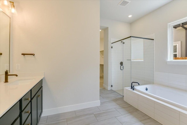 1404 S Brook Dr, Leander, TX 78641 - full bathroom with a stall shower, a garden tub, vanity, a walk in closet, and baseboards