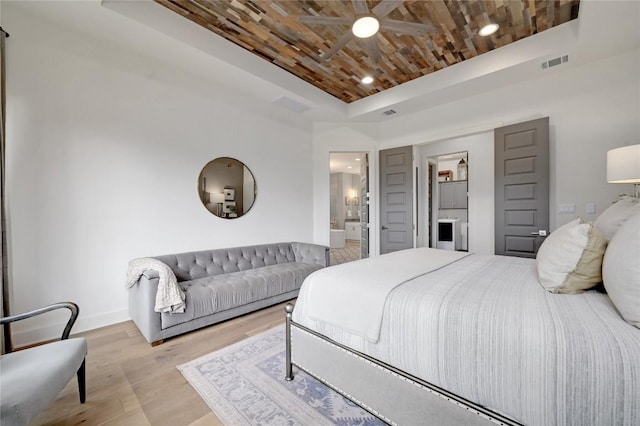 125 Reataway Dr, Dripping Springs, TX 78620 - bedroom with wood finished floors, baseboards, wood ceiling, ensuite bath, and a tray ceiling