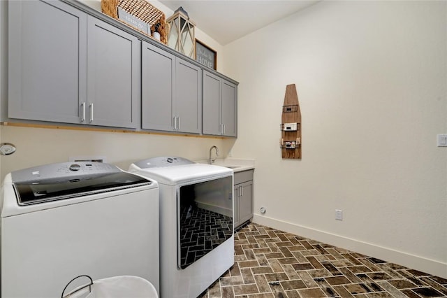 125 Reataway Dr, Dripping Springs, TX 78620 - laundry room with washer and clothes dryer, baseboards, cabinet space, and brick patterned floors