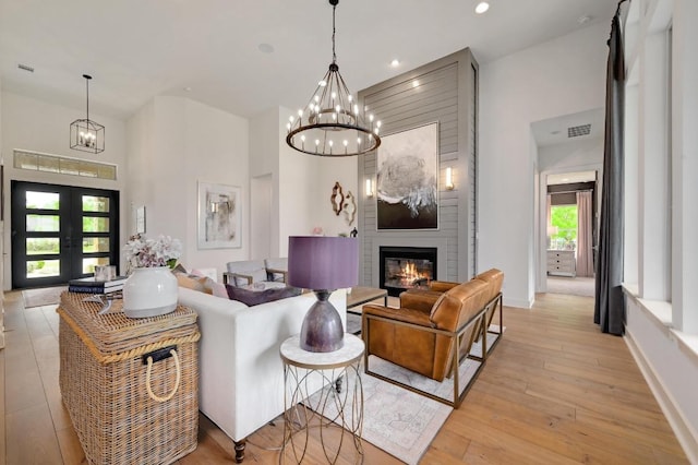 125 Reataway Dr, Dripping Springs, TX 78620 - living area featuring a chandelier, french doors, a large fireplace, light wood finished floors, and recessed lighting
