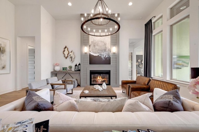 125 Reataway Dr, Dripping Springs, TX 78620 - living room with a chandelier, wood finished floors, a large fireplace, and recessed lighting