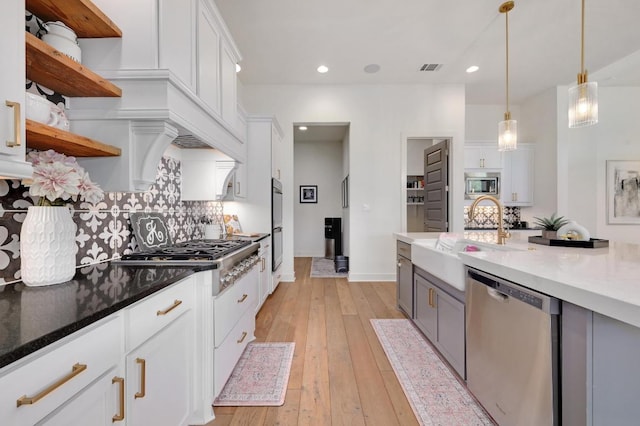 125 Reataway Dr, Dripping Springs, TX 78620 - kitchen with appliances with stainless steel finishes, open shelves, backsplash, a sink, and light wood-style flooring