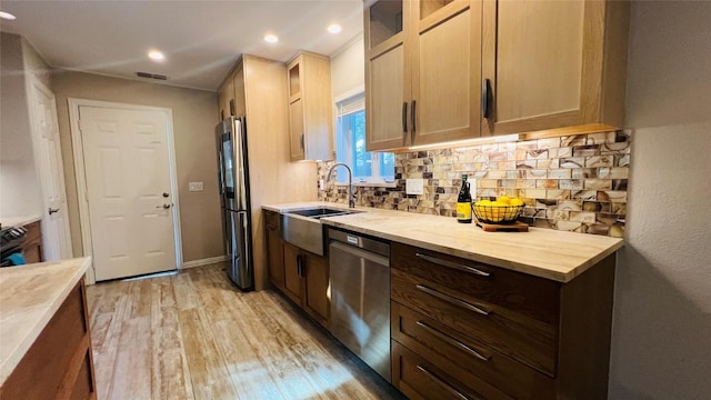 4807 Gerona Dr, Austin, TX 78759 - kitchen featuring appliances with stainless steel finishes, tasteful backsplash, light wood-type flooring, glass insert cabinets, and recessed lighting