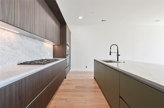 2209 S 1st St Unit 408, Austin, TX 78704 - kitchen featuring a sink, stainless steel gas cooktop, modern cabinets, tasteful backsplash, and recessed lighting