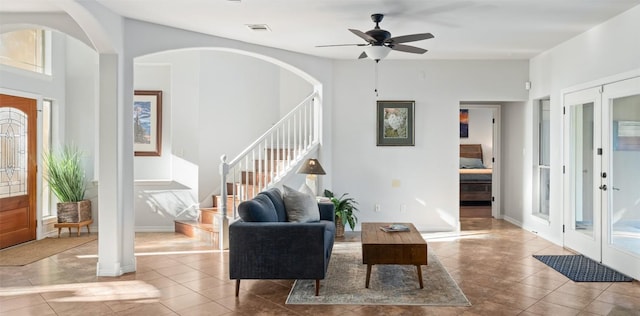 tiled entrance foyer with stairway, ceiling fan, arched walkways, french doors, and visible vents