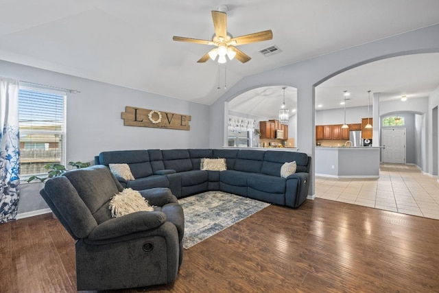 1416 Muddy Waters Dr, Pflugerville, TX 78660 - living room featuring arched walkways, vaulted ceiling, a ceiling fan, and light wood-style flooring