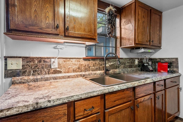 4701 Milburn Ln, Austin, TX 78702 - kitchen with a sink, tasteful backsplash, light countertops, and brown cabinetry