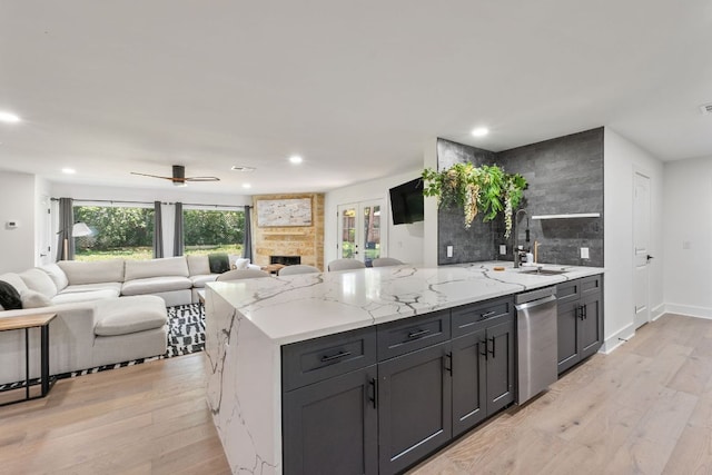 5800 Marilyn Dr, Austin, TX 78757 - kitchen featuring stainless steel dishwasher, a sink, light wood-style floors, open floor plan, and recessed lighting