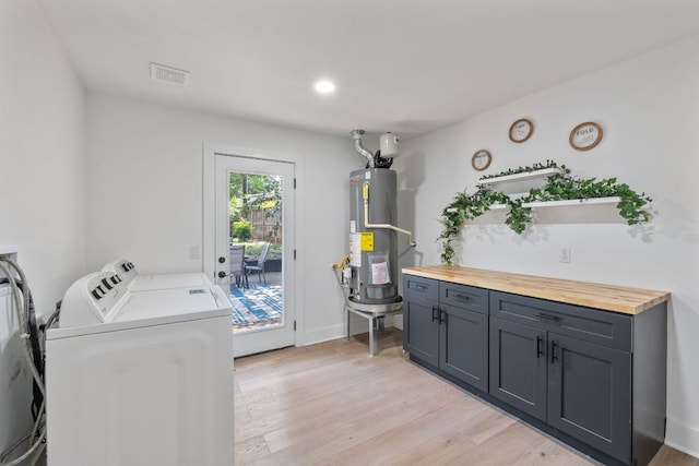5800 Marilyn Dr, Austin, TX 78757 - laundry room with gas water heater, washing machine and dryer, light wood finished floors, and cabinet space