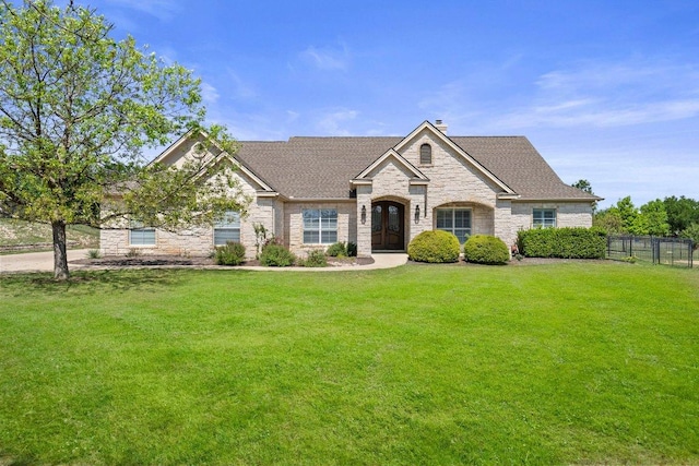 604 Lake Side Cv, Georgetown, TX 78628 - french provincial home featuring fence, stone siding, french doors, and a front yard