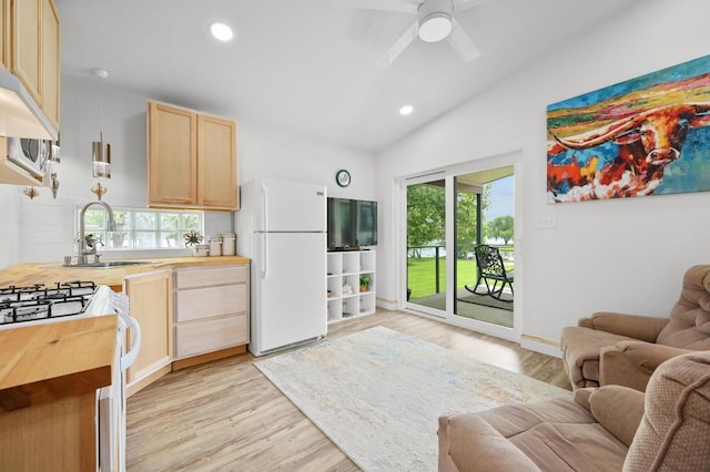 kitchen featuring wood counters, freestanding refrigerator, open floor plan, and light brown cabinets
