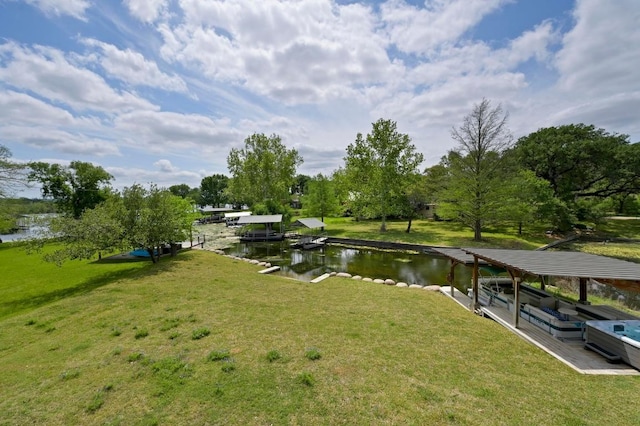view of dock with a lawn and a water view