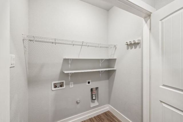 206 N Winston Dr, Fredericksburg, TX 78624 - washroom featuring dark wood-style floors, hookup for an electric dryer, gas dryer hookup, baseboards, and washer hookup