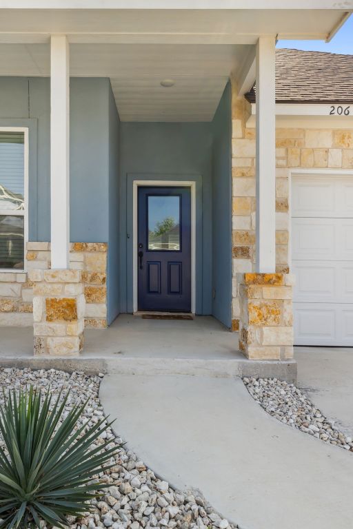 206 N Winston Dr, Fredericksburg, TX 78624 - doorway to property featuring stone siding and covered porch