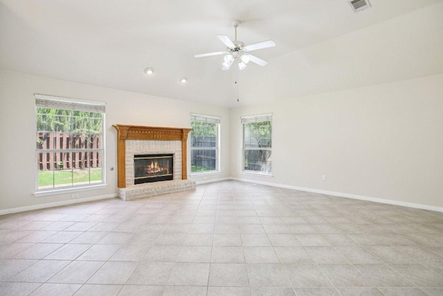 10120 Treasure Island Dr, Austin, TX 78730 - unfurnished living room with healthy amount of natural light, vaulted ceiling, baseboards, a fireplace, and light tile patterned floors