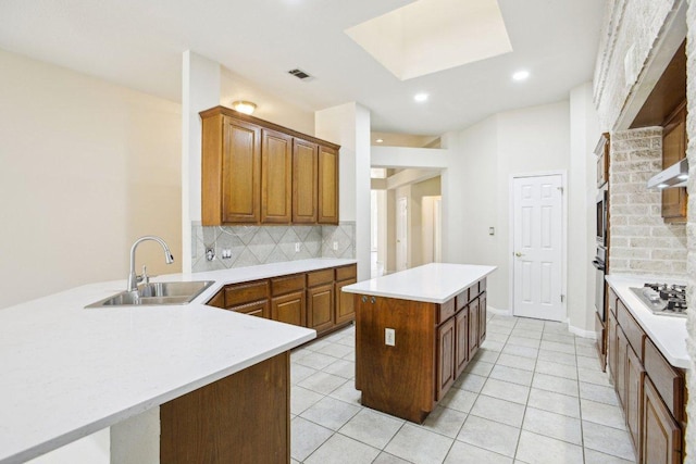 10120 Treasure Island Dr, Austin, TX 78730 - kitchen with a sink, backsplash, a center island, light countertops, and gas stovetop