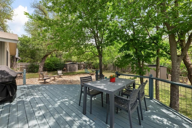 12511 Tree Line Dr, Austin, TX 78729 - wooden terrace with a storage unit, outdoor dining area, an outdoor structure, and a fenced backyard