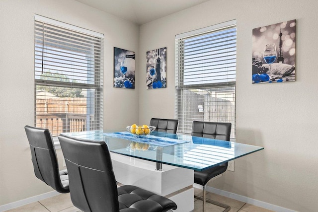 tiled dining space with healthy amount of natural light and baseboards