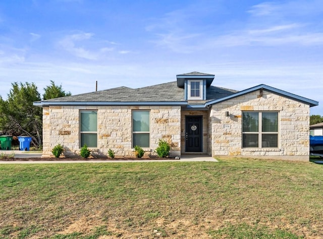 view of front facade with stone siding and a front lawn