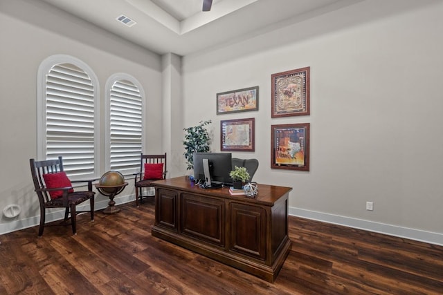 office with dark wood-style floors, baseboards, visible vents, and a raised ceiling