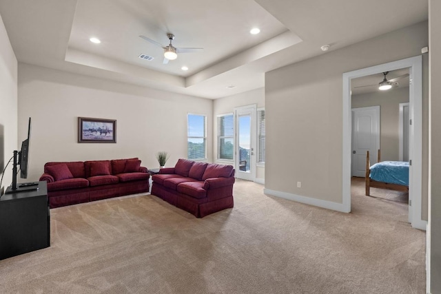 living area featuring ceiling fan, a raised ceiling, light colored carpet, visible vents, and recessed lighting