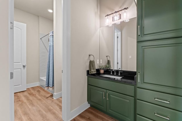 bathroom featuring baseboards, recessed lighting, wood finished floors, a shower with shower curtain, and vanity