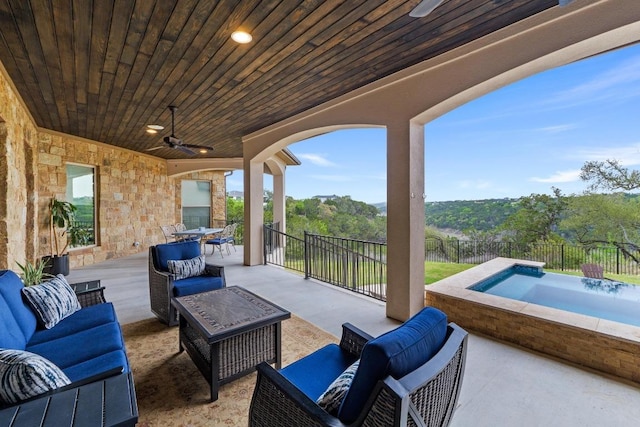 view of patio / terrace featuring a jacuzzi, a fenced backyard, outdoor lounge area, and a ceiling fan