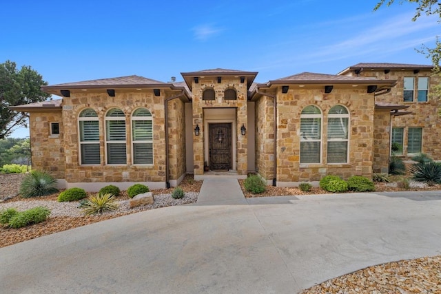mediterranean / spanish home with stone siding