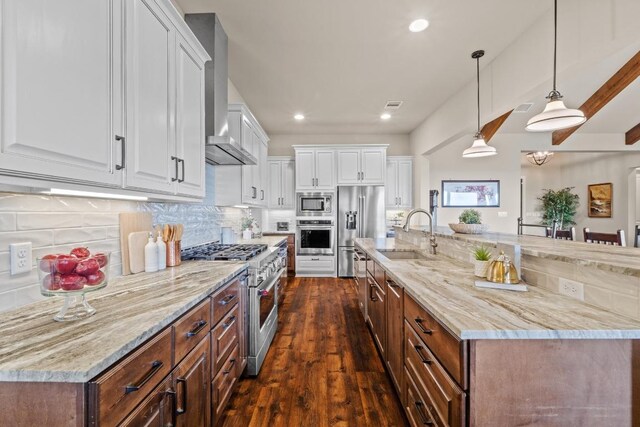 kitchen featuring a sink, dark wood finished floors, white cabinetry, wall chimney range hood, and high quality appliances